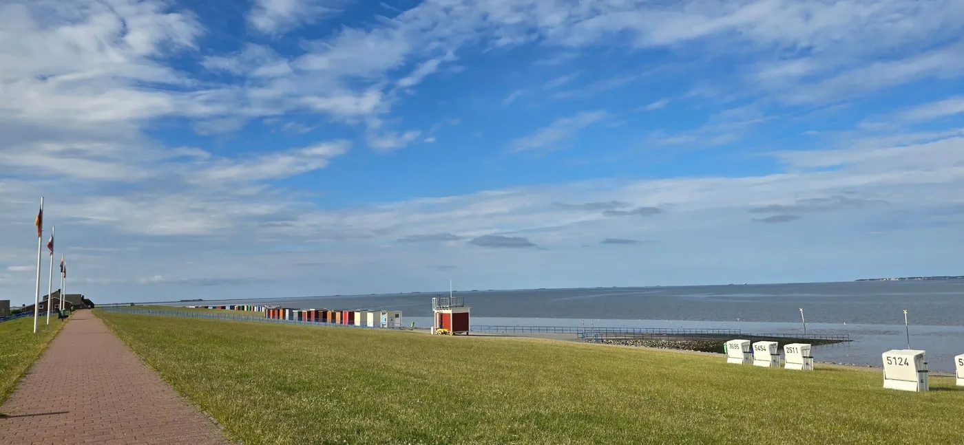 Weg auf dem verstärkten Deich in Dagebüll mit Badebuden und Strandkörben
