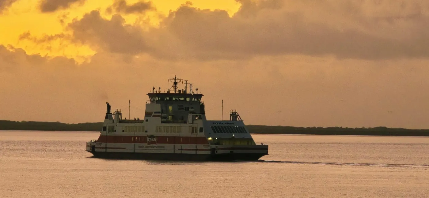 Fähre der Wyker Dampfschiffs-Reederei auf dem Wasser unter goldenem Abendhimmel