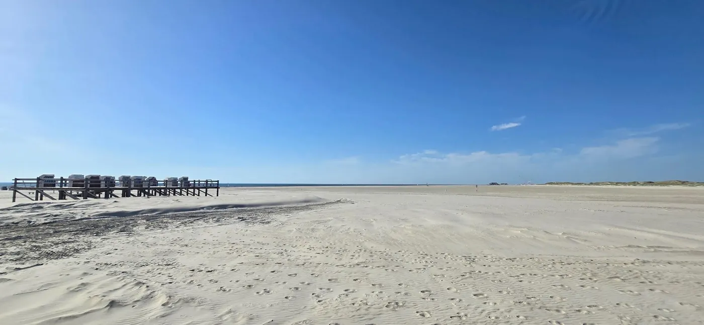 Weiter Sandstrand von St. Peter-Ording mit Strandkörben in der Ferne